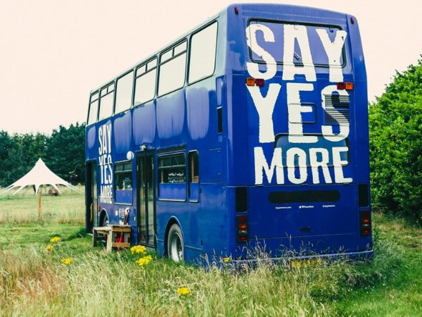 converted bus with the text 'Say Yes More' on the back